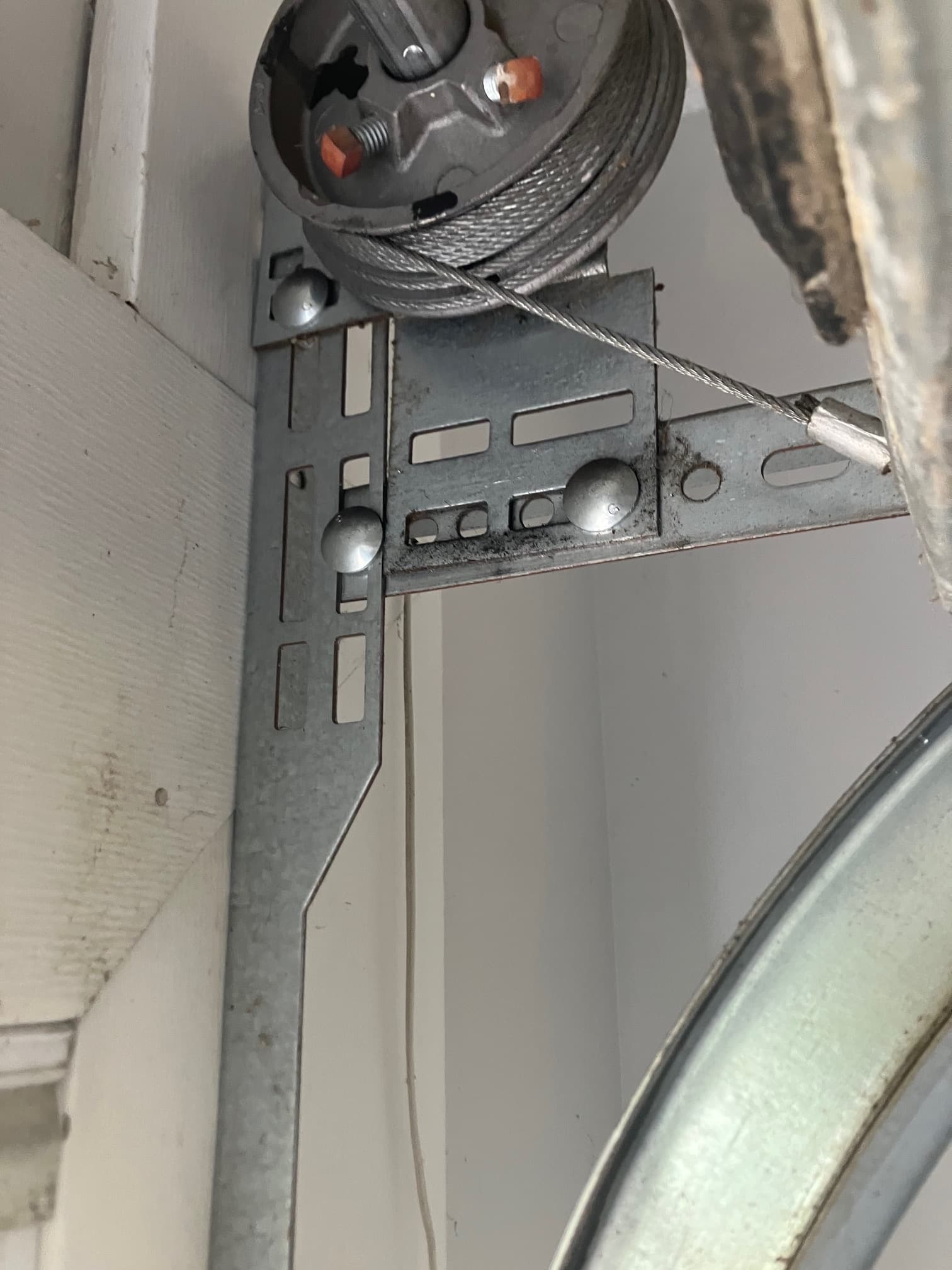 Close-up of wound garage door lift cable and stop sleeve on drum