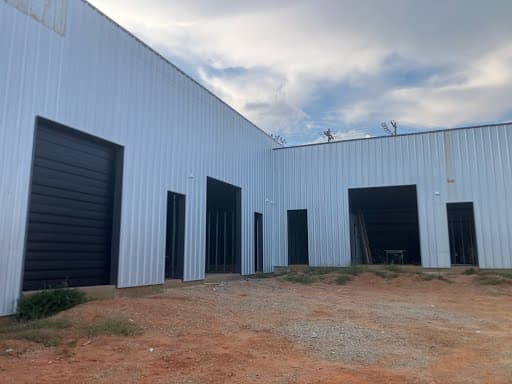 Industrial building bay construction showing roll-up door installation