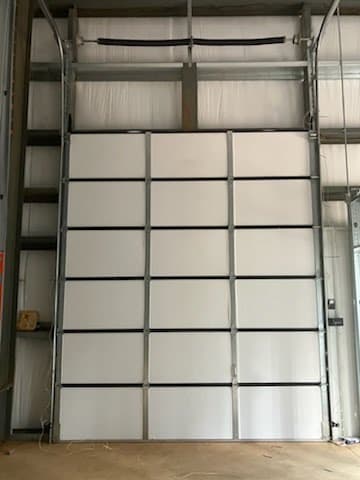 High-lift commercial sectional door with overhead torsion shaft installed