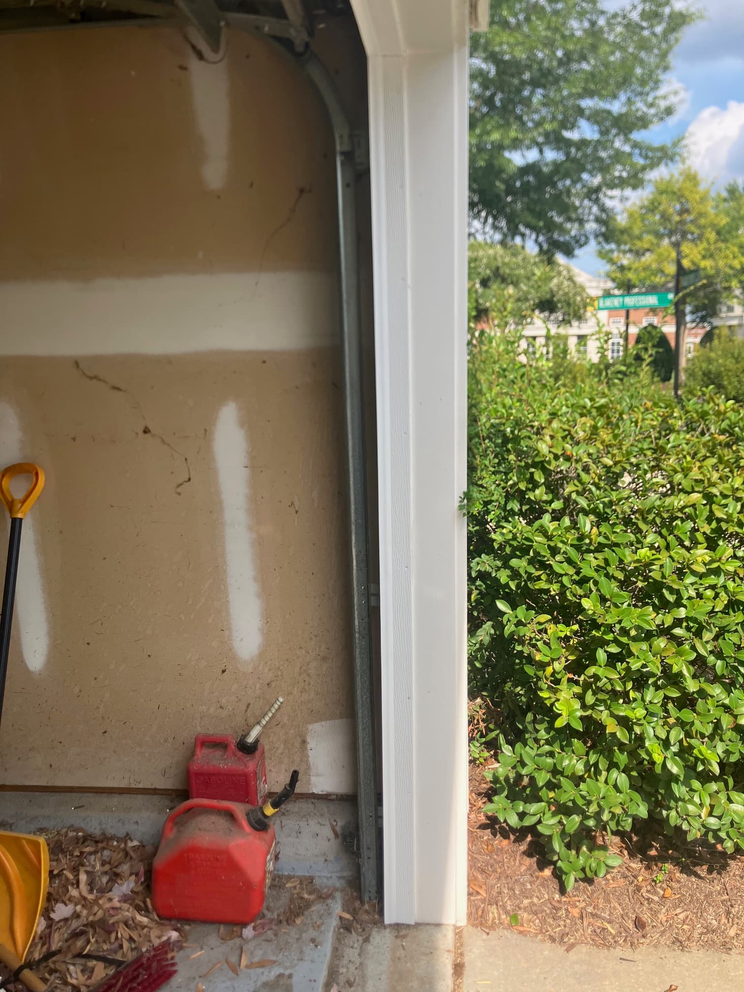 Vertical garage door track alignment along exterior casing