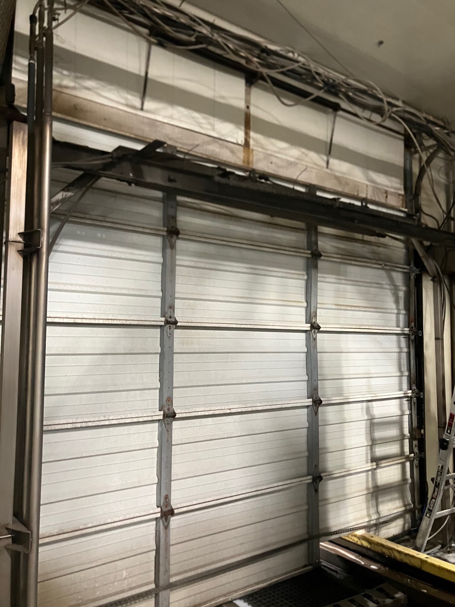 Bent upper panel frame and misaligned commercial door